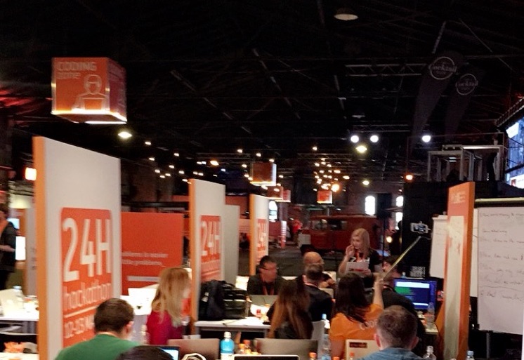 Teams arbeiten bei einem 24-Stunden-Hackathon in einer großen Halle
